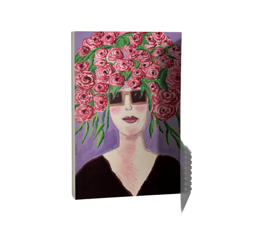 Notebook with a design of a woman's face wearing a headband of pink flowers on a purple background.