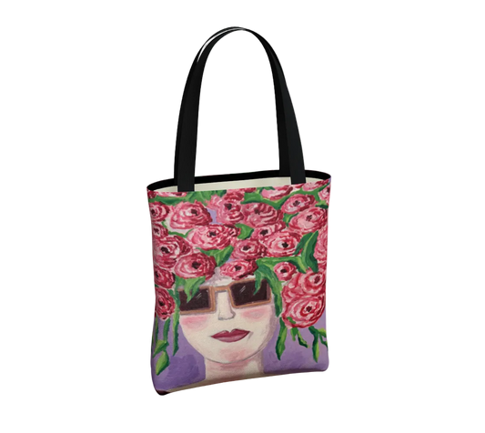 Tote bag with a design of a face with flowers and sunglasses on a white background