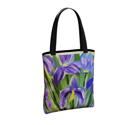 A tote bag featuring a colorful painting of purple irises on a light gray background.